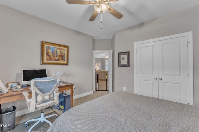 carpeted bedroom featuring a closet, baseboards, and ceiling fan