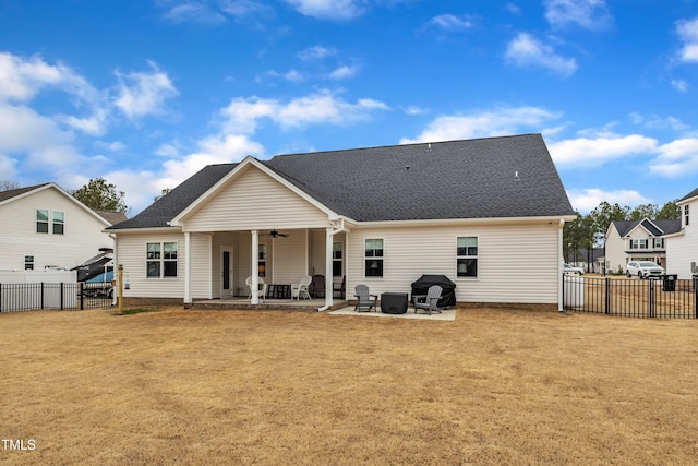 rear view of property with roof with shingles, a lawn, a patio, a fenced backyard, and a ceiling fan