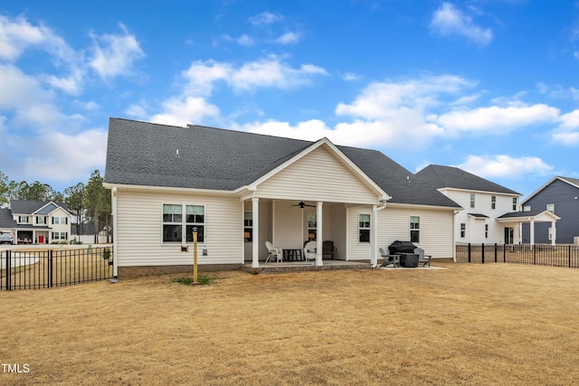 back of property featuring a shingled roof, a fenced backyard, a yard, a patio area, and a ceiling fan