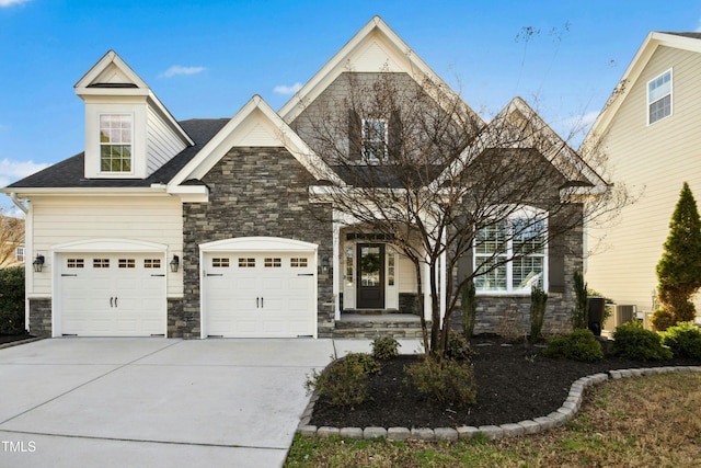 view of front of property with stone siding, an attached garage, and driveway