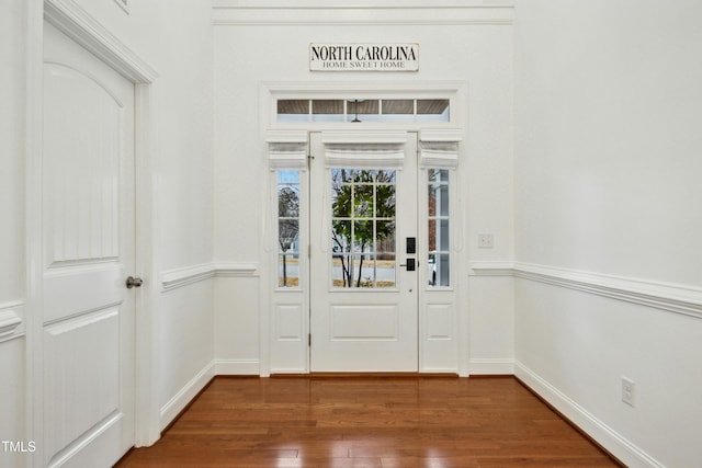 foyer entrance featuring baseboards and dark wood finished floors