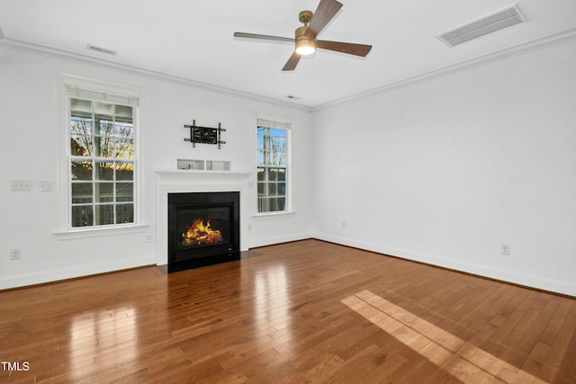 unfurnished living room with visible vents, crown molding, baseboards, and hardwood / wood-style flooring