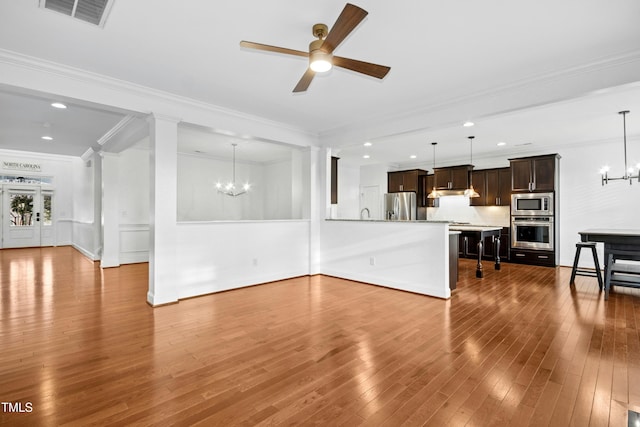 living room with visible vents, ornamental molding, ceiling fan with notable chandelier, recessed lighting, and wood-type flooring