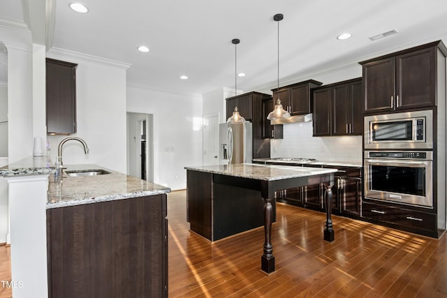 kitchen featuring visible vents, dark brown cabinets, dark wood finished floors, appliances with stainless steel finishes, and a sink