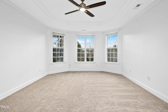 spare room featuring baseboards, a tray ceiling, ornamental molding, carpet flooring, and a ceiling fan