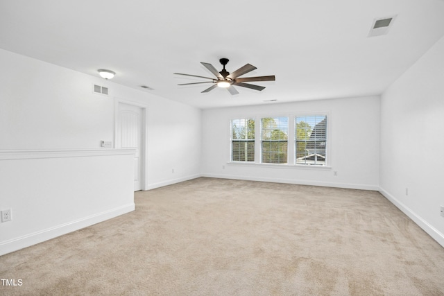 unfurnished room featuring visible vents, baseboards, light colored carpet, and ceiling fan