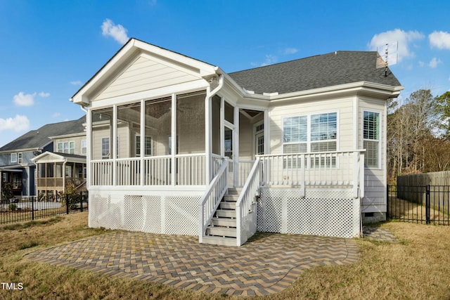 rear view of property featuring a shingled roof, fence, stairs, a sunroom, and crawl space