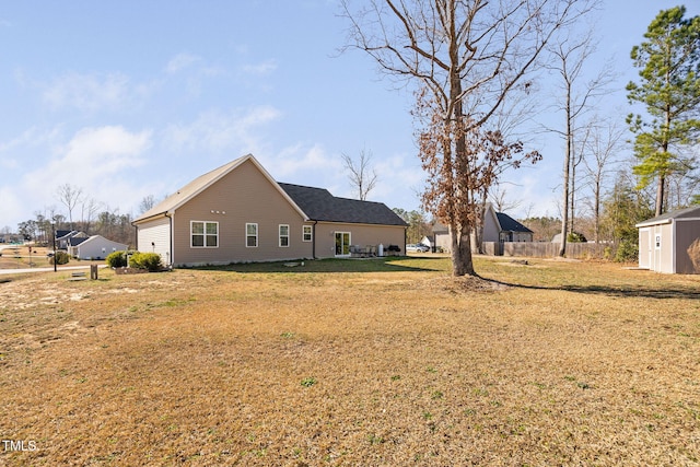 exterior space featuring a yard, a storage unit, an outdoor structure, and fence