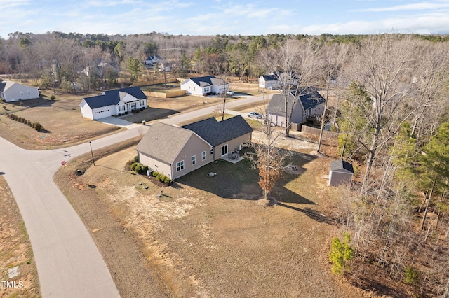 birds eye view of property featuring a view of trees