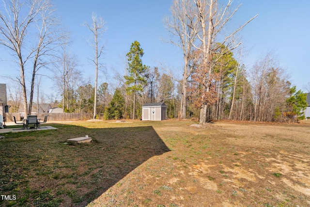 view of yard with an outbuilding, a storage shed, and fence