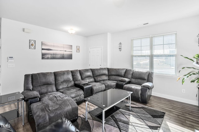 living room featuring visible vents, baseboards, and wood finished floors