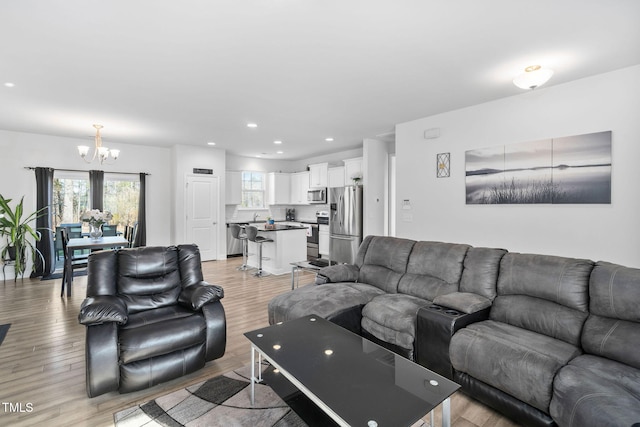 living area featuring recessed lighting, a chandelier, and light wood finished floors