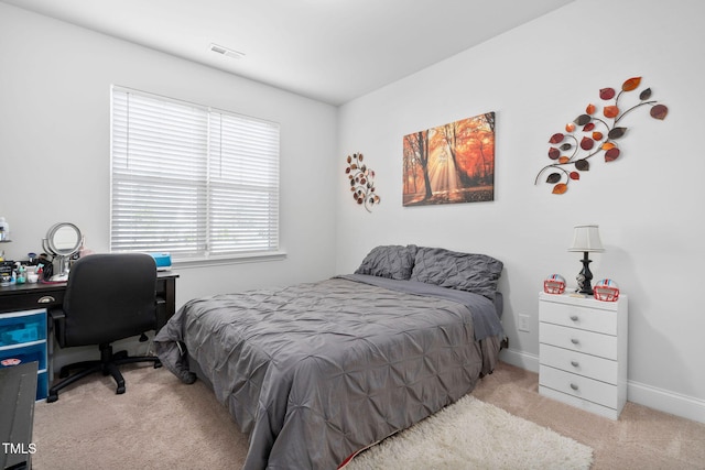 bedroom featuring baseboards, visible vents, and light carpet