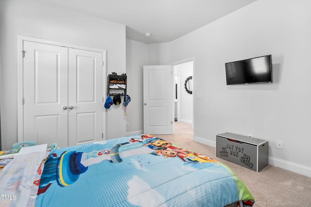 carpeted bedroom with a closet and baseboards