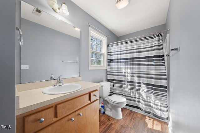 bathroom with vanity, wood finished floors, visible vents, curtained shower, and toilet