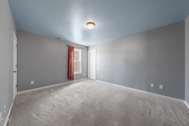 carpeted empty room featuring visible vents and baseboards