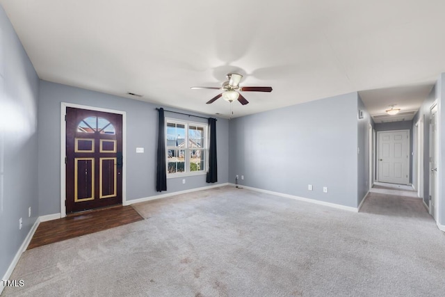 carpeted foyer with baseboards and a ceiling fan