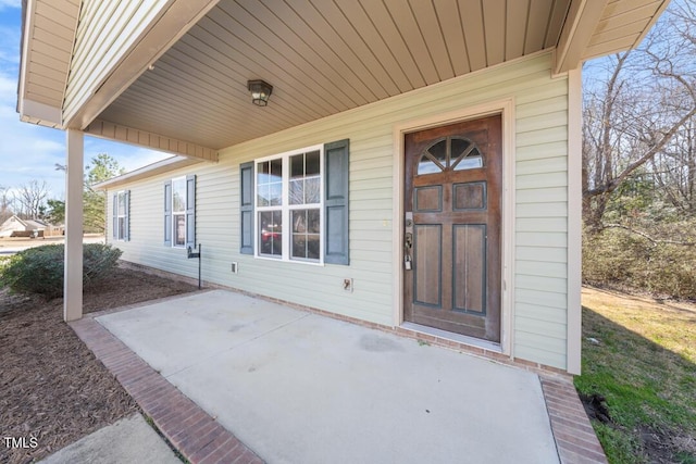 view of exterior entry with a patio