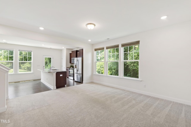 97 Begonia St, Angier, NC 27501 - unfurnished living room featuring dark carpet, a sink, baseboards, plenty of natural light, and recessed lighting