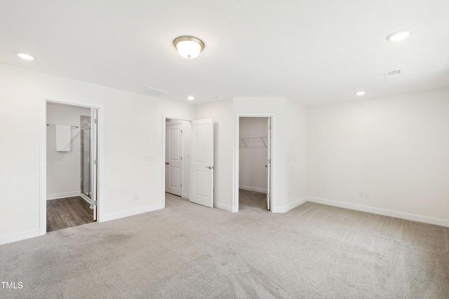97 Begonia St, Angier, NC 27501 - unfurnished bedroom featuring light carpet, a spacious closet, recessed lighting, baseboards, and a closet