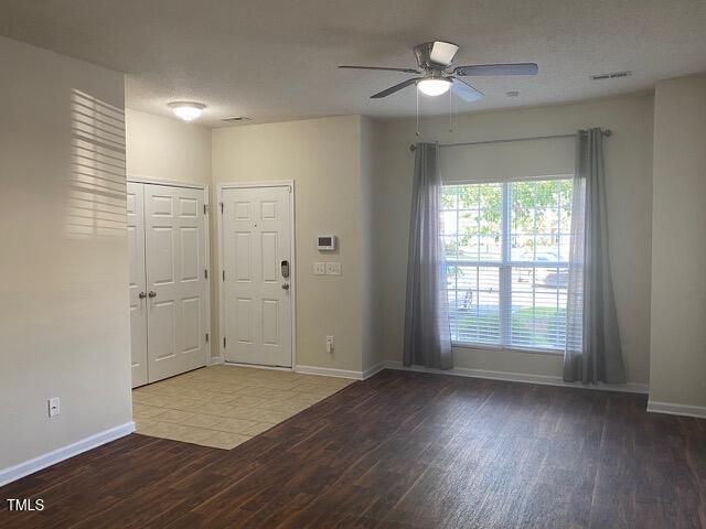 foyer featuring baseboards, wood finished floors, and a ceiling fan