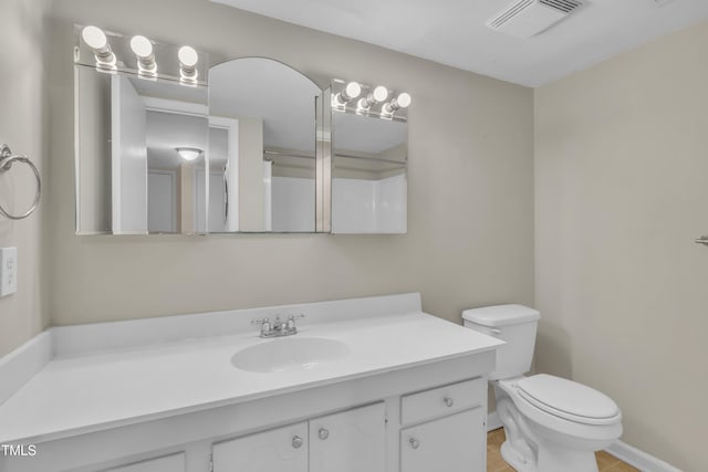 bathroom featuring visible vents, toilet, and vanity