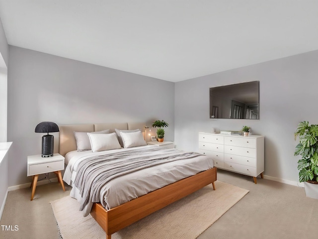 bedroom with baseboards and light carpet