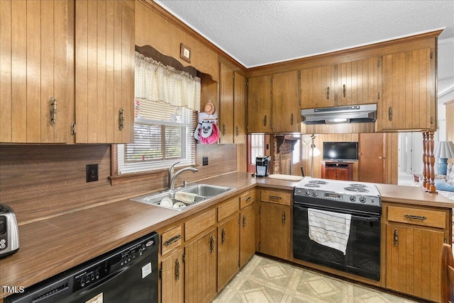 kitchen with black appliances, brown cabinetry, under cabinet range hood, and a sink