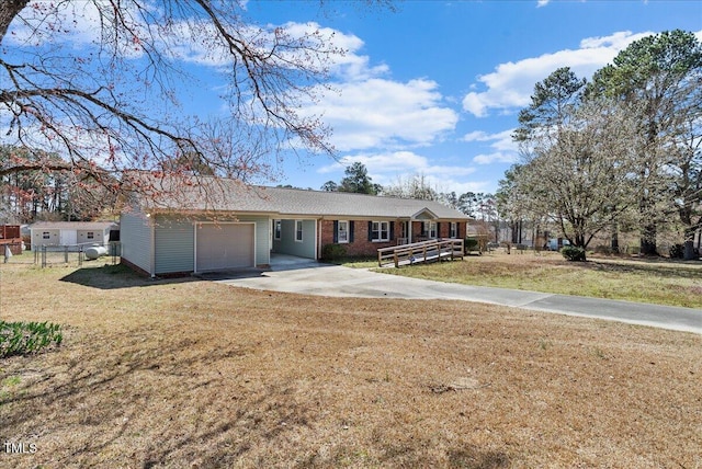 ranch-style house with brick siding, a front lawn, fence, concrete driveway, and an attached garage