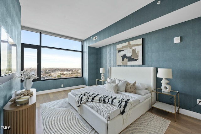 bedroom with visible vents, baseboards, and wood finished floors