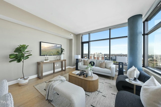 living room featuring visible vents, baseboards, and wood finished floors