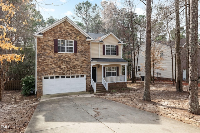 traditional-style home featuring fence, a porch, a garage, stone siding, and driveway