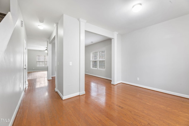 empty room featuring ceiling fan, baseboards, and wood-type flooring