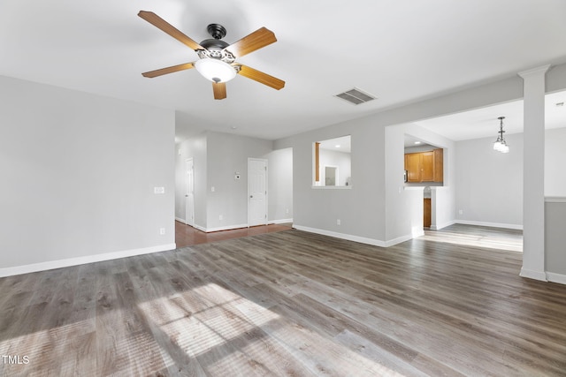 unfurnished living room with a ceiling fan, wood finished floors, visible vents, and baseboards