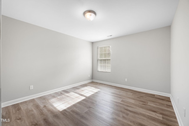 unfurnished room featuring baseboards and wood finished floors