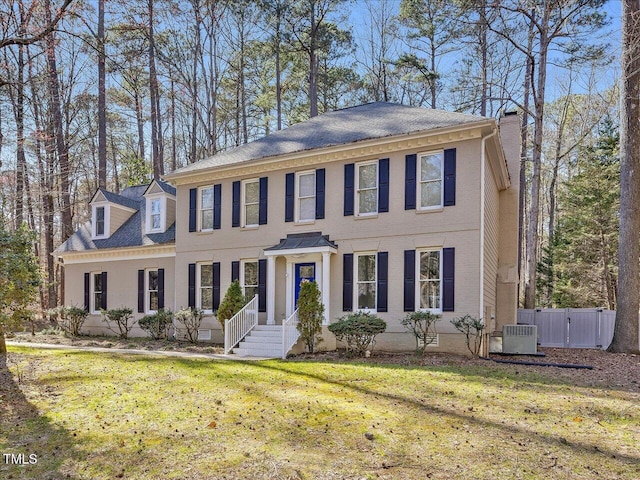 colonial-style house with crawl space, cooling unit, a front yard, and fence