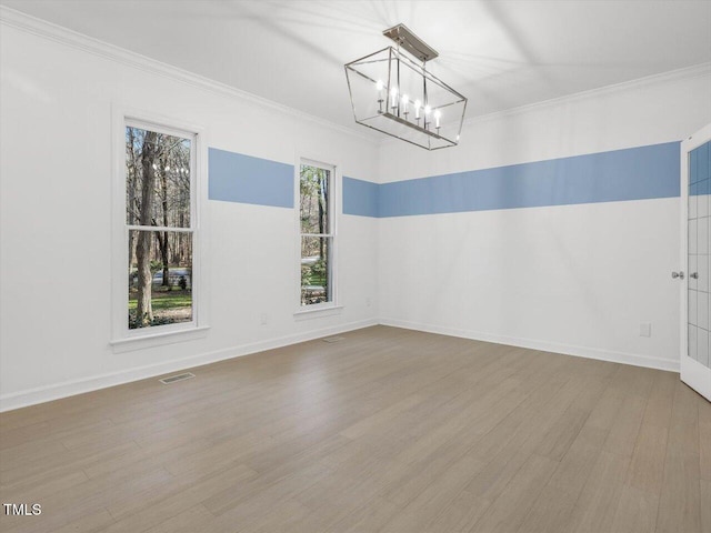 interior space with wood finished floors, baseboards, visible vents, ornamental molding, and a notable chandelier