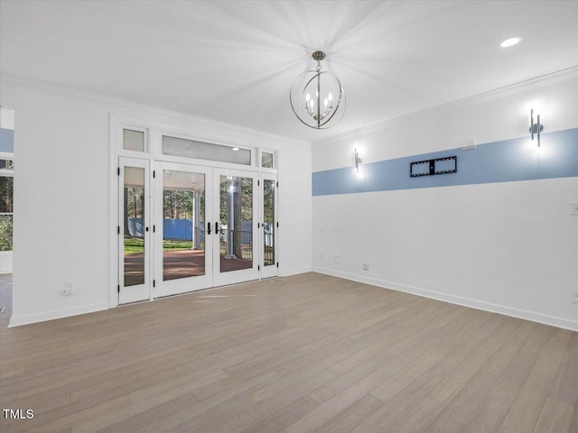 empty room featuring french doors, wood finished floors, and ornamental molding