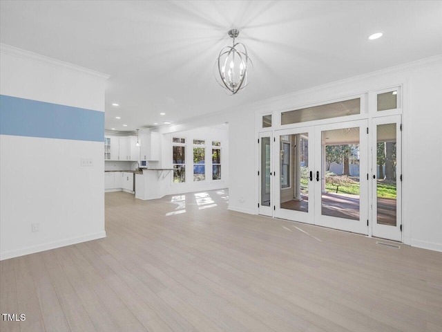 unfurnished living room featuring french doors, baseboards, crown molding, and light wood-style floors