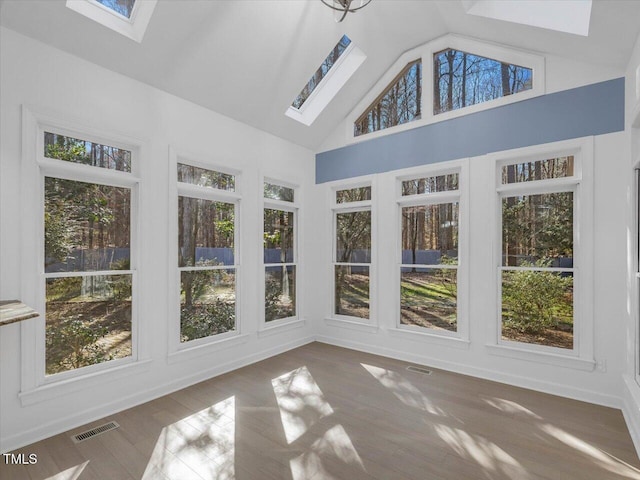 unfurnished sunroom featuring visible vents and vaulted ceiling with skylight