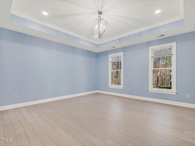 unfurnished room featuring visible vents, baseboards, wood finished floors, a notable chandelier, and a raised ceiling