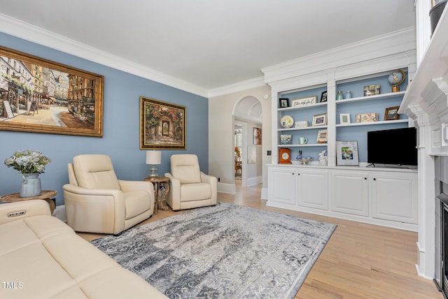12500 Richmond Run Dr, Raleigh, NC 27614 - living area featuring crown molding, arched walkways, light wood-style floors, baseboards, and a fireplace