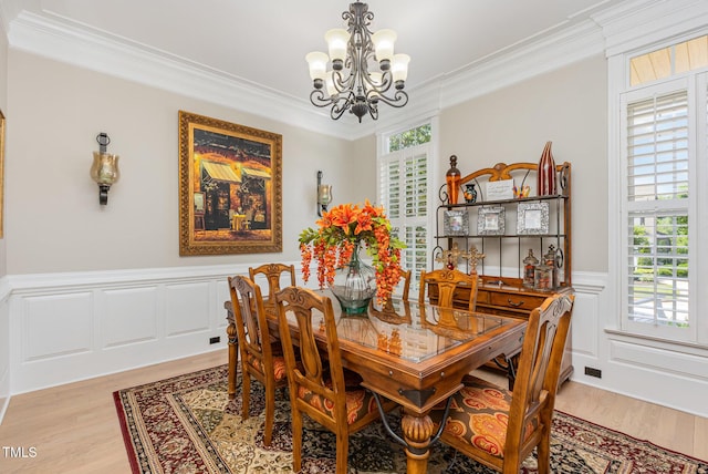 12500 Richmond Run Dr, Raleigh, NC 27614 - dining room featuring a chandelier, ornamental molding, light wood-type flooring, a wainscoted wall, and a decorative wall