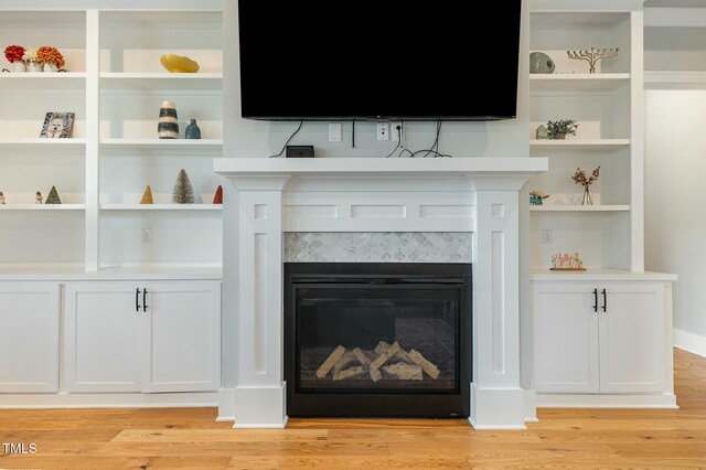 interior details with a glass covered fireplace and wood finished floors