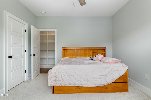 bedroom featuring light carpet, a closet, baseboards, and a ceiling fan