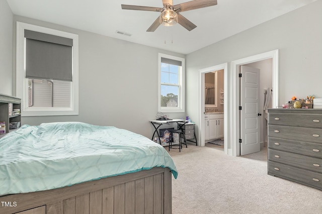 carpeted bedroom featuring a ceiling fan, visible vents, and ensuite bathroom