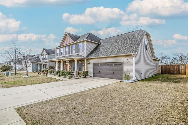 view of front of property featuring fence, concrete driveway, a front yard, roof with shingles, and a garage