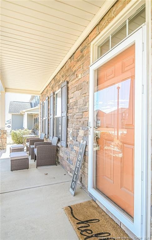 exterior space with covered porch and stone siding