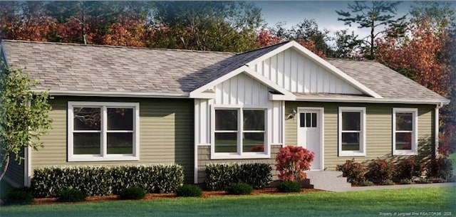 view of front of house with board and batten siding, roof with shingles, and a front lawn