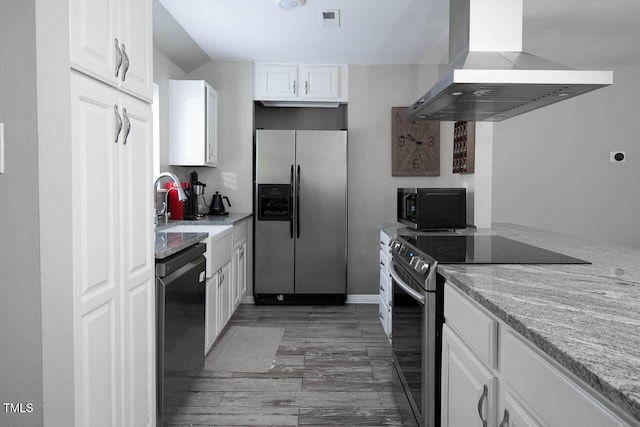 kitchen featuring visible vents, light wood-style flooring, island exhaust hood, appliances with stainless steel finishes, and white cabinetry